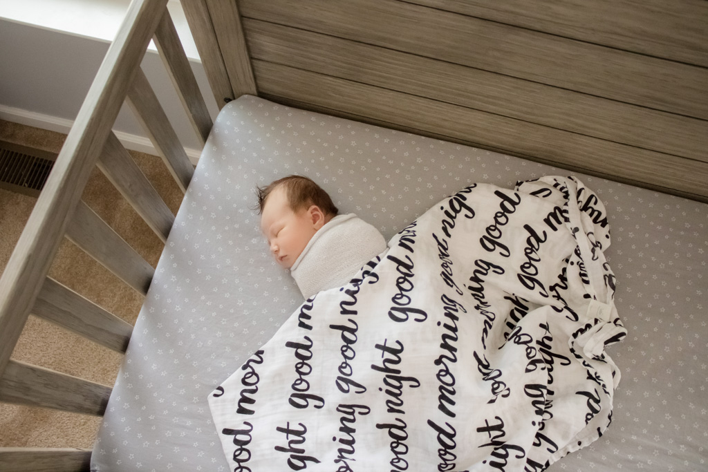 newborn baby in crib lifestyle session