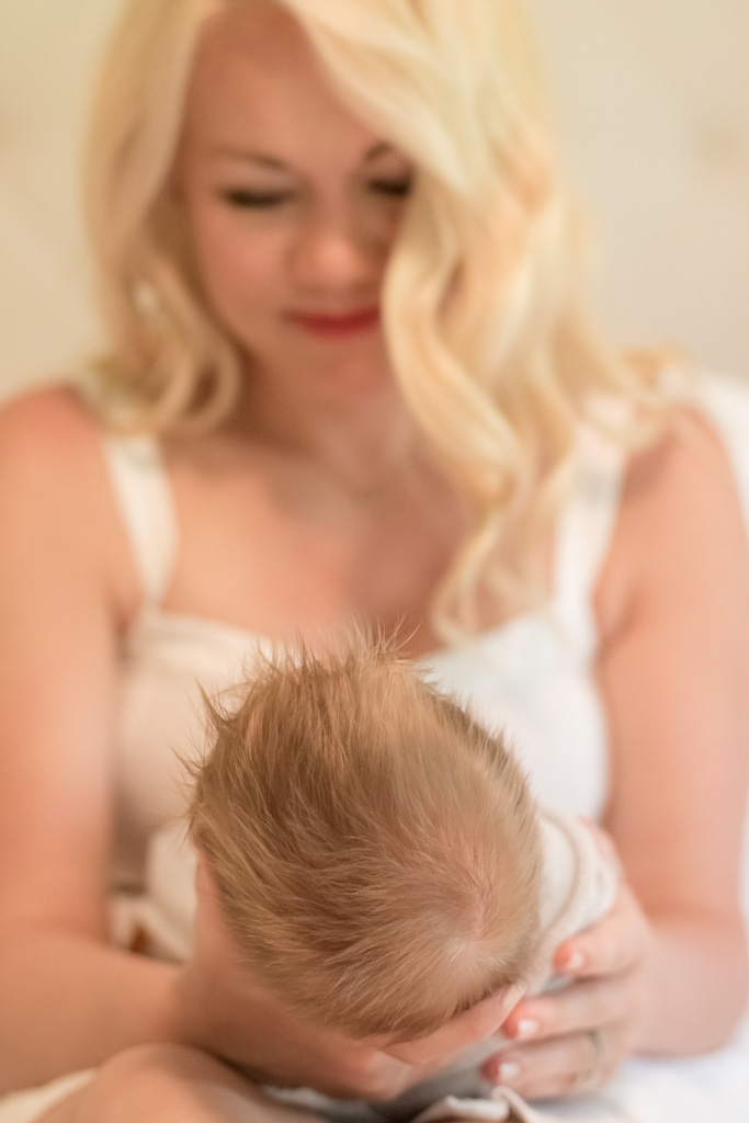 mother looking at newborn baby with full head of hair