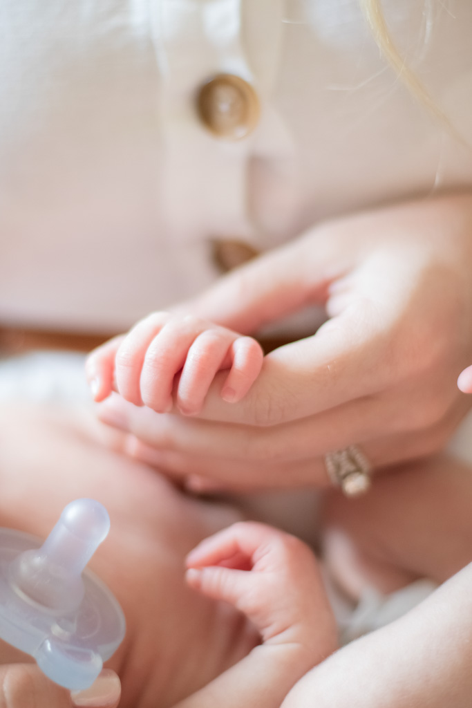 mother holding newborn's tiny hand
