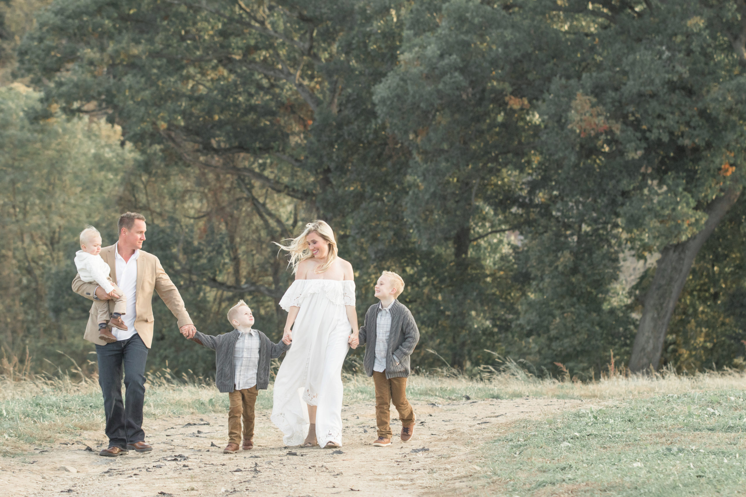 styled family walking on path through field at sunset | petite magnolia photography