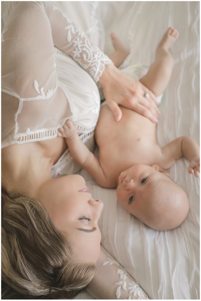 mother laying on bed with newborn_petite magnolia photography 