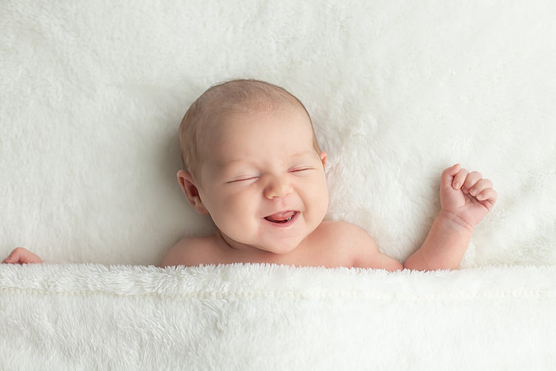 newborn photos pittsburgh, pa newborn girl on white blanket smiling