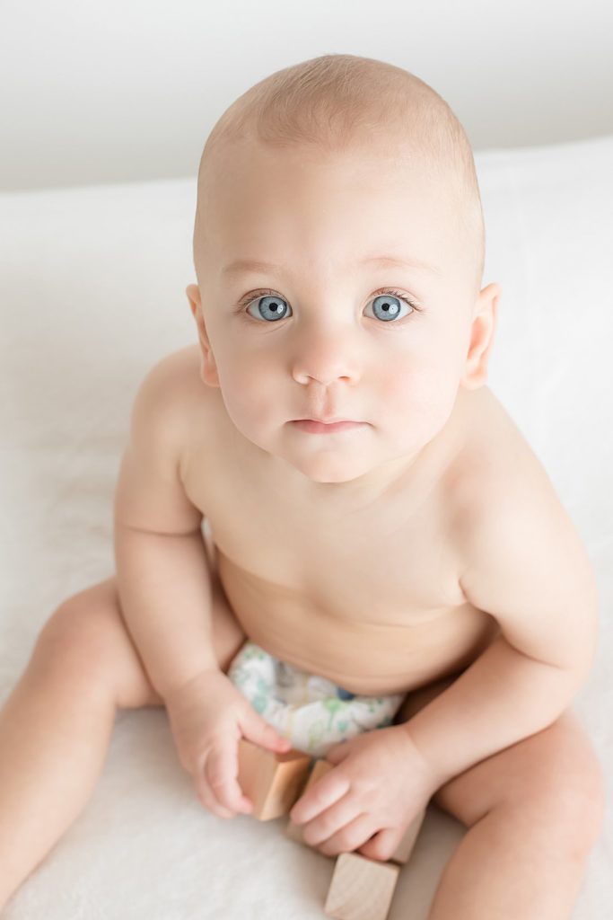 pittsburgh baby photography, baby boy on white bedding playing with wooden blocks