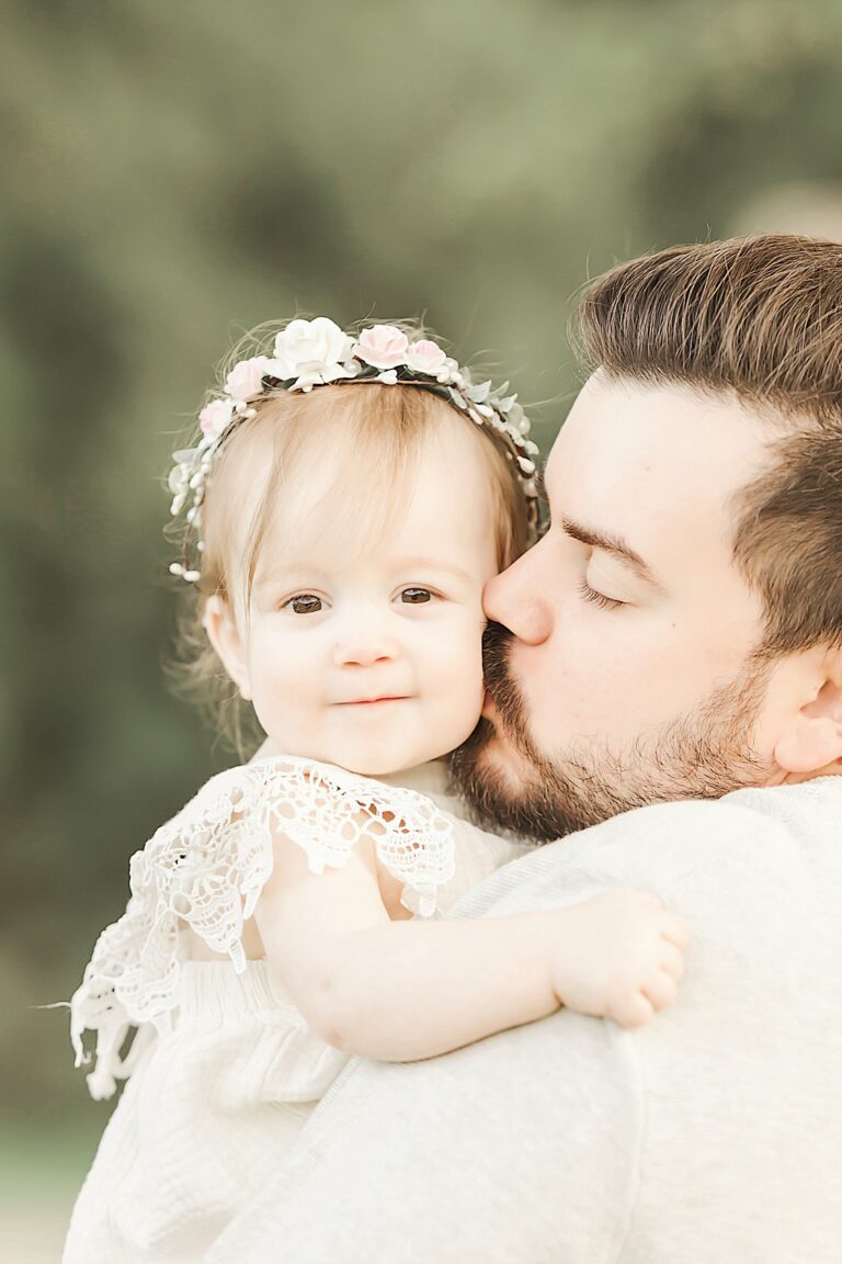 father kissing baby girl on cheek_petite magnolia photography