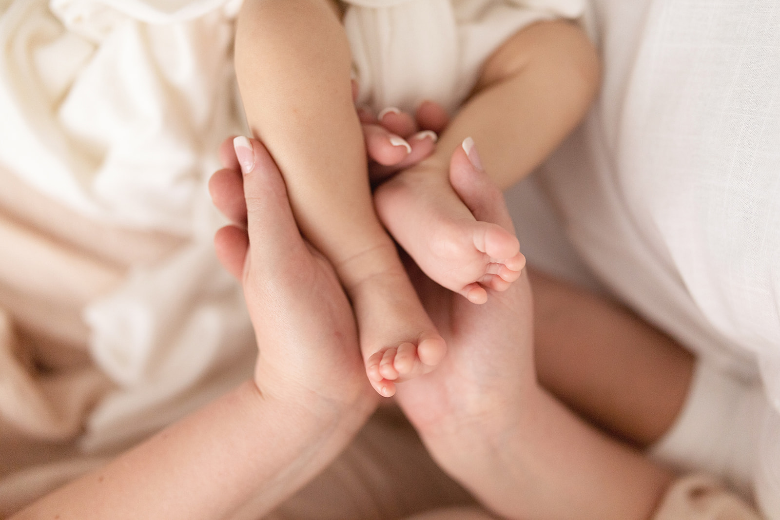 Details of a mother holding her baby's feet Happy Baby Company