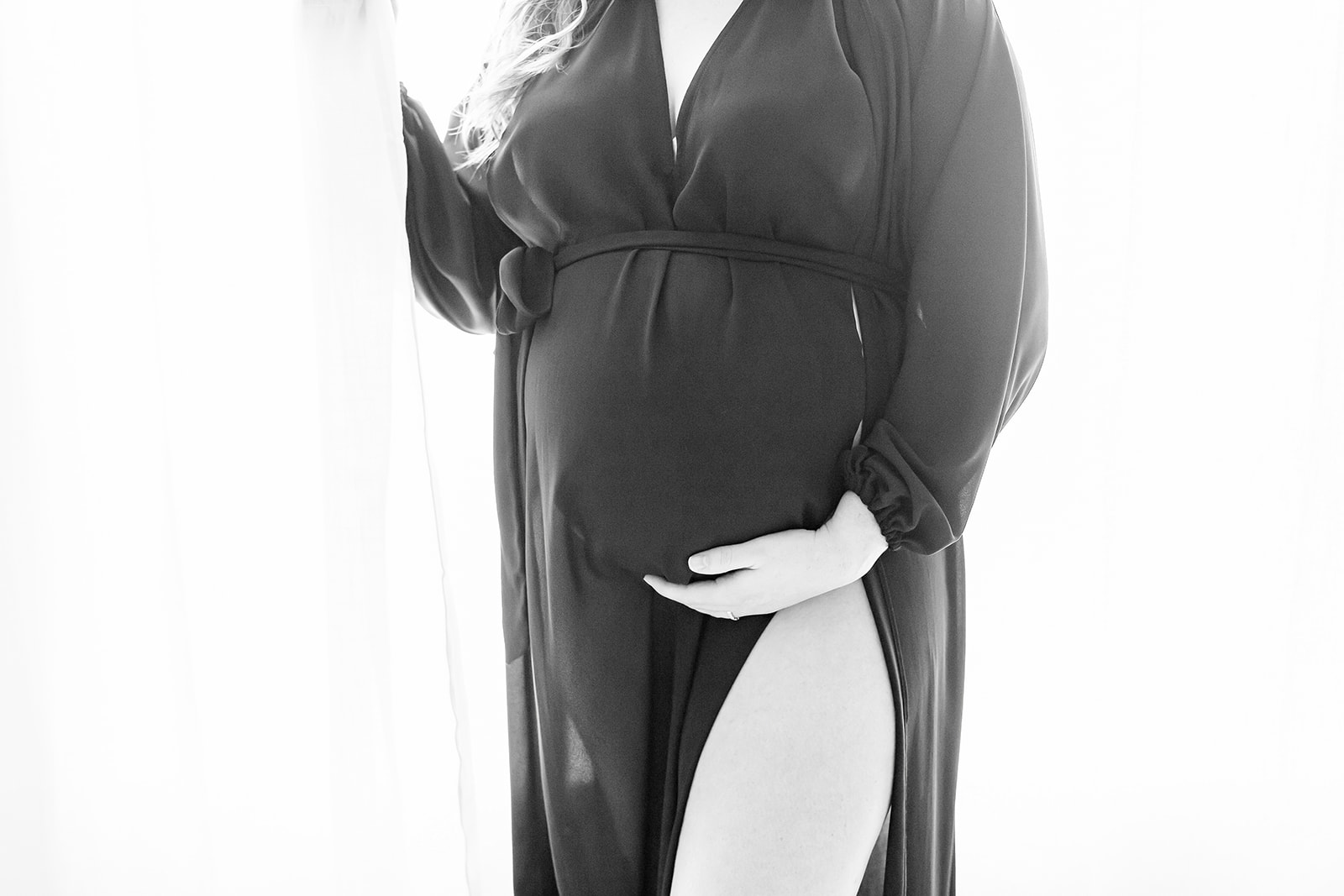 A mom-to-be stands in a window wearing a black robe hey baby! 4D Ultrasound