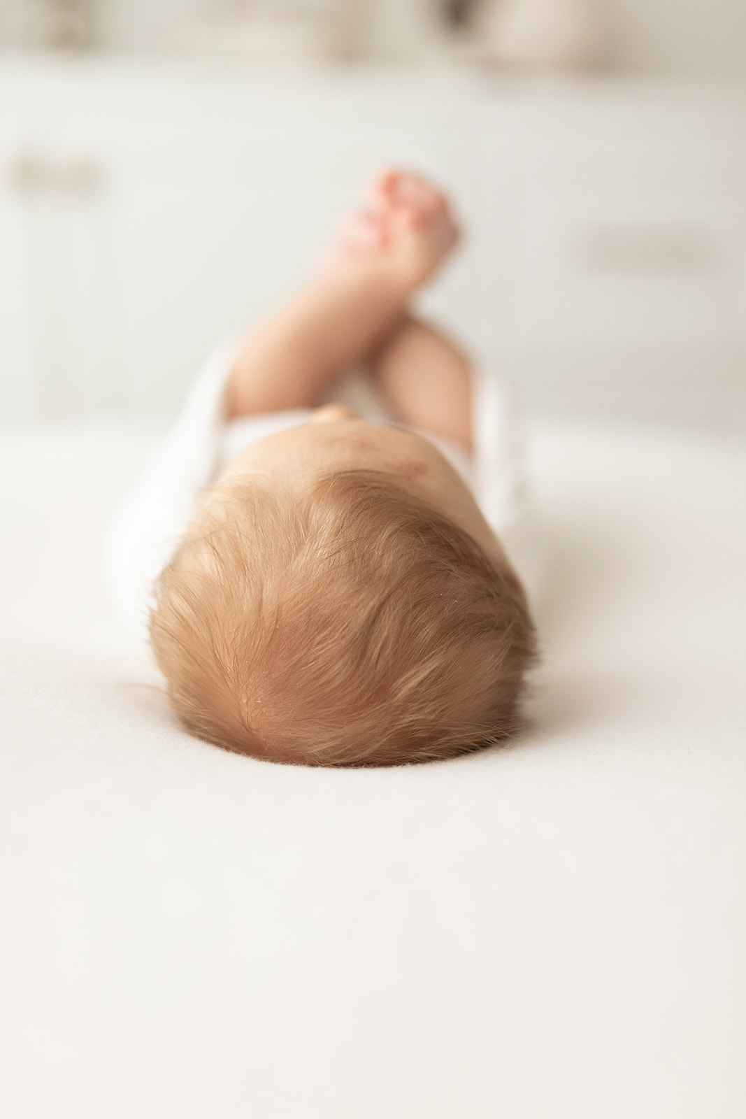 Details of a sleeping newborn baby laying on a bed