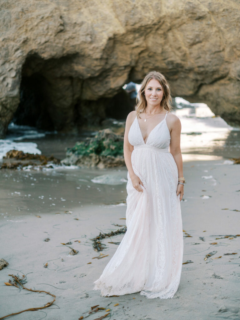 Pittsburgh newborn & family photographer from Petite Magnolia Photography standing on beach in long dress.